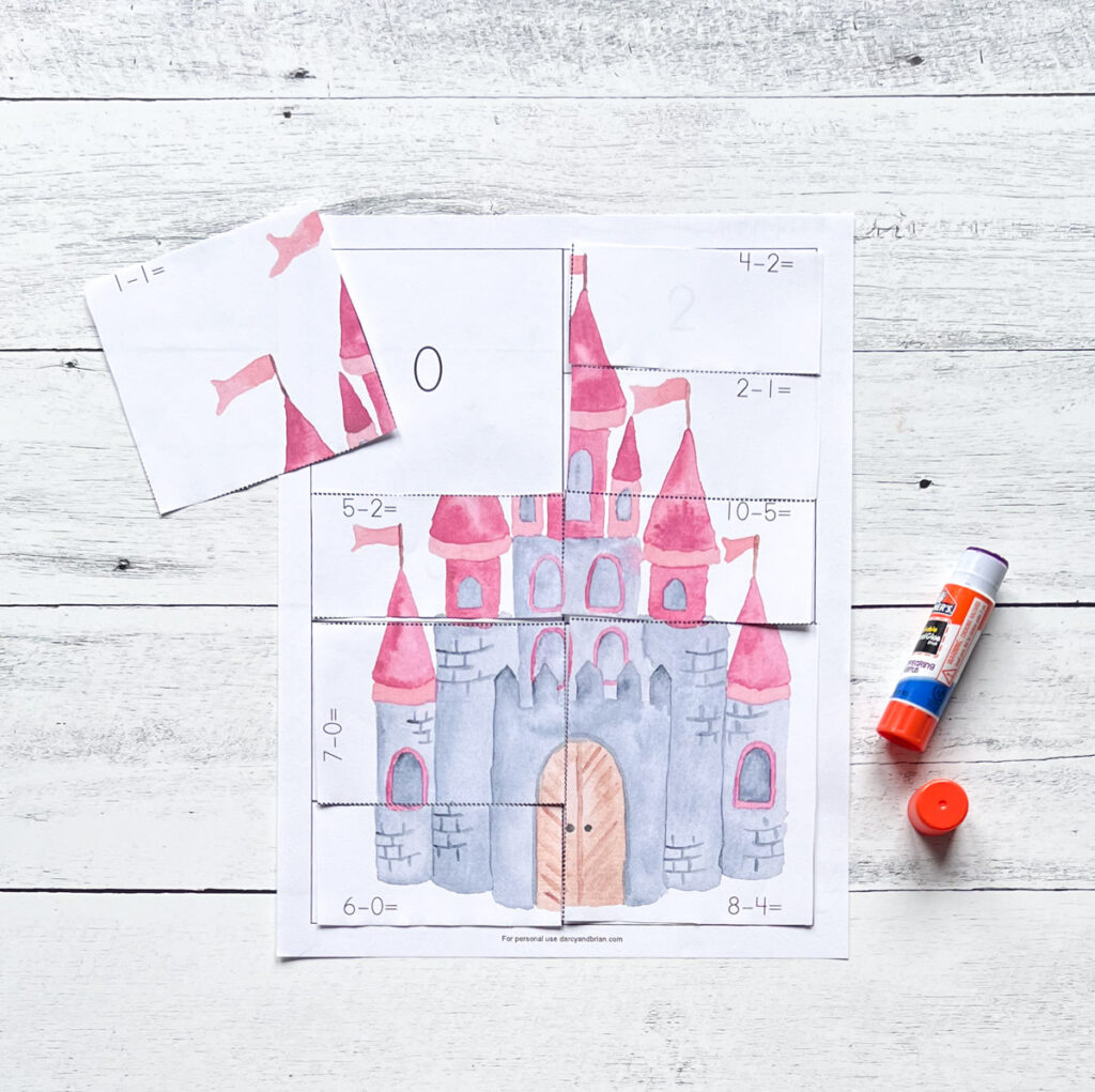 Picture of a watercolor castle with pink turret towers and flags being glued to the answer page.