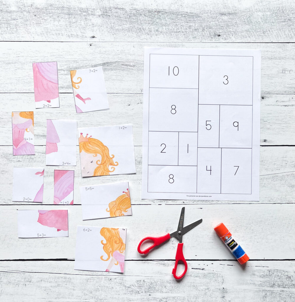 Various square and rectangular pieces of a princess wearing a pink dress are cut apart and mixed up next to a worksheet with a numbers in boxes.