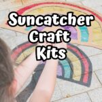 Child holding out a rainbow suncatcher made with cardboard and clear plastic making a colorful rainbow on the sidewalk. White text in the center says Suncatcher Craft Kits