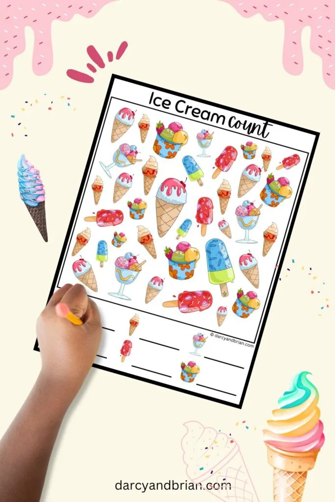Child's hand holding a pencil over the bottom of the colorful ice cream search and count page.