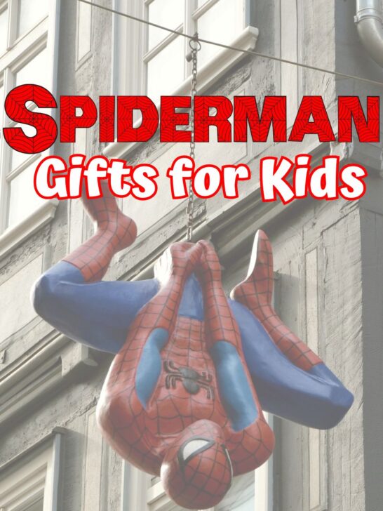 Red and white text says Spiderman Gifts for Kids. A large plastic Spiderman hanging from a chain in front of a building is the background.