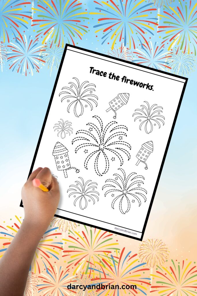 Mockup of child's hand holding a pencil over worksheet with firework bursts and rockets with dashed outlines.