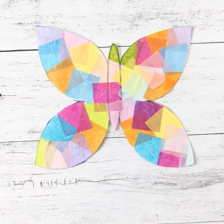 Close up view of faux stained glass paper suncatcher shaped like a butterfly.