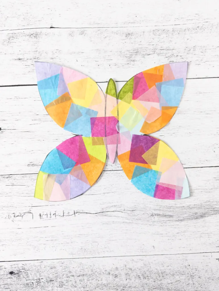 Close up view of faux stained glass paper suncatcher shaped like a butterfly.