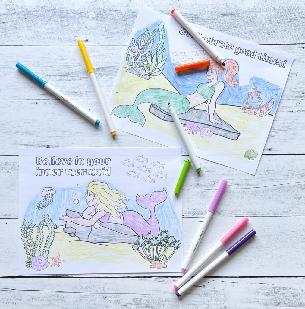 Markers laying across mermaid themed coloring pages that say "believe in your inner mermaid" and "shell-ebrate good times!"