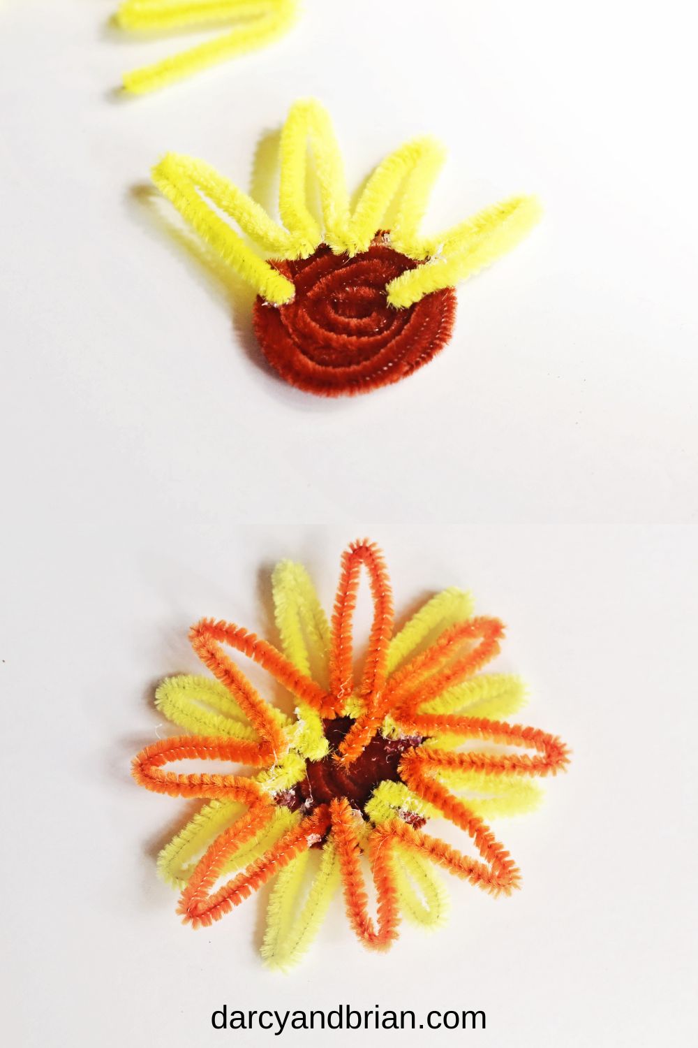 Showing the yellow and orange chenille stems bent to create petals and hot glued to back of coiled brown one.