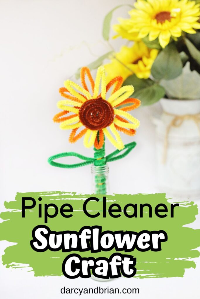 Cute sunflower made using pipe cleaners and a pencil standing up in a small vase. Decorate faux sunflowers decorate the back of the picture. Text on lower half says Pipe Cleaner Sunflower Craft on a light green splash brush stroke.