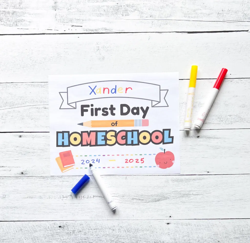 Blue, yellow, and red markers lay next to paper sign for the start of the homeschool year.