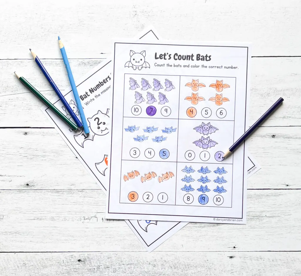 Two pages printed out and filled in with crayons and colored pencils. Top worksheet focuses on counting different quantities of bats.