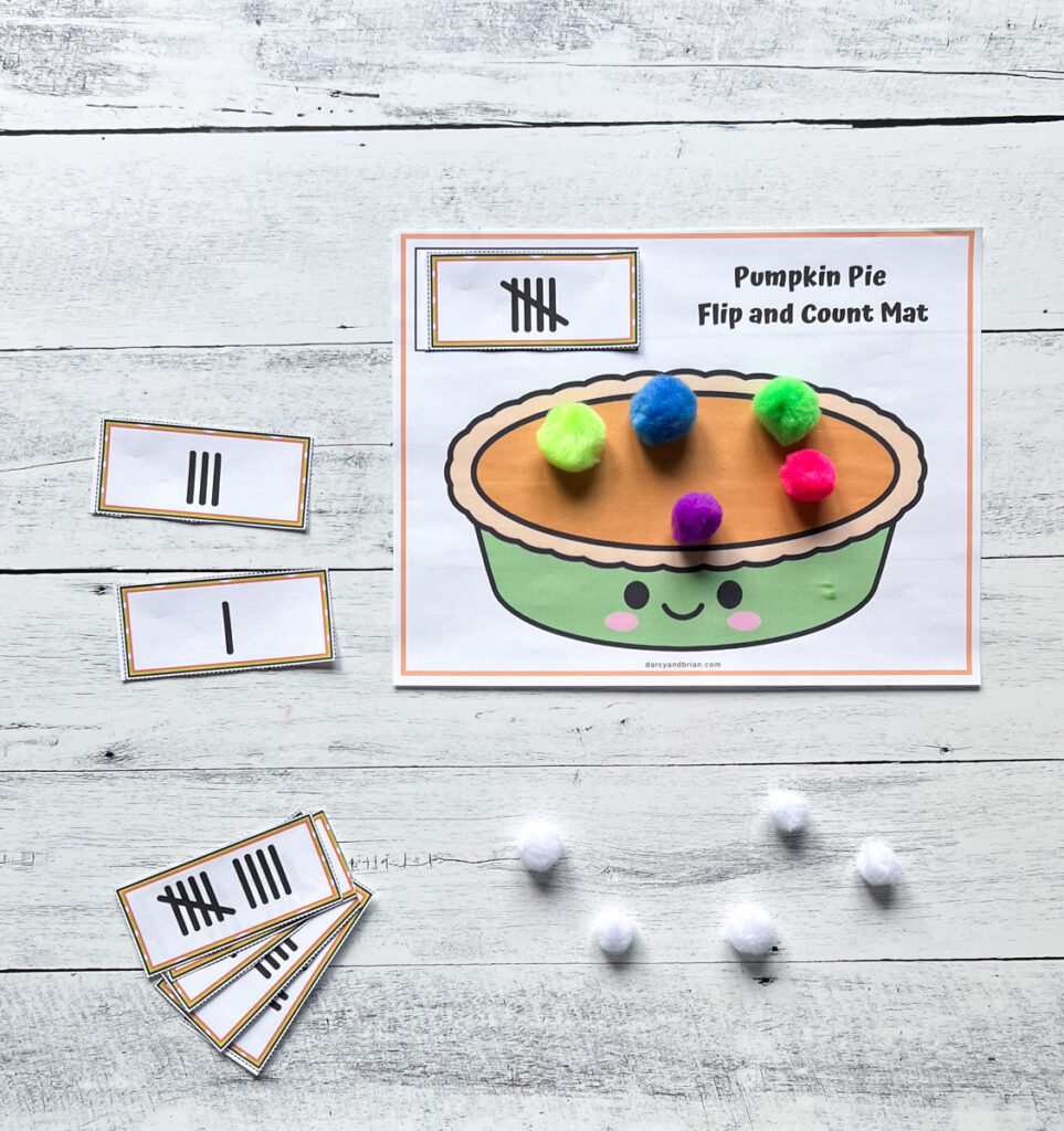 Cards with tally marks next to pie counting mat. Colorful pom poms on top of pie picture to match the number card on it.