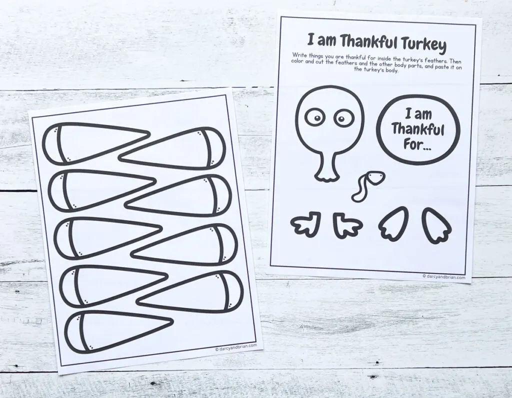 Two pages of I am Thankful worksheet printed out and ready to be colored and cut out. They are laying on a black and white wood background.