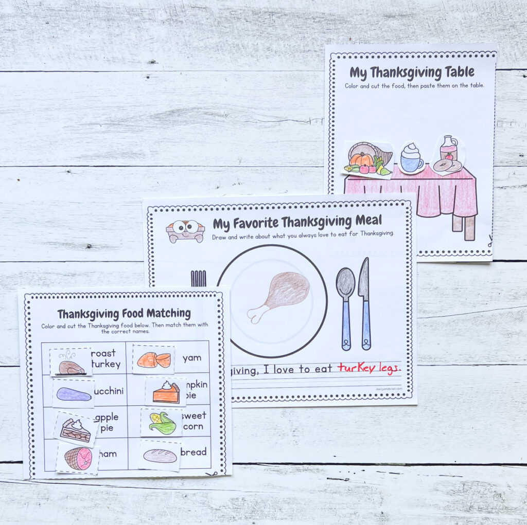 There are three sample worksheets placed in a black and white wood background that can be a great example in doing these activities. One is a drawing of food on a plate, another matches food items to words, and another is cut and paste dinner table activity.