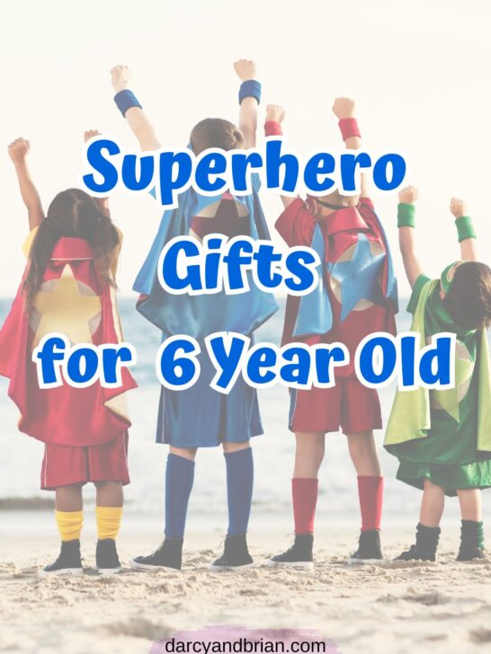 Blue text says Superhero Gifts for 6 Year Old over a picture of four children wearing capes and raising their hands in the air while standing on the beach.