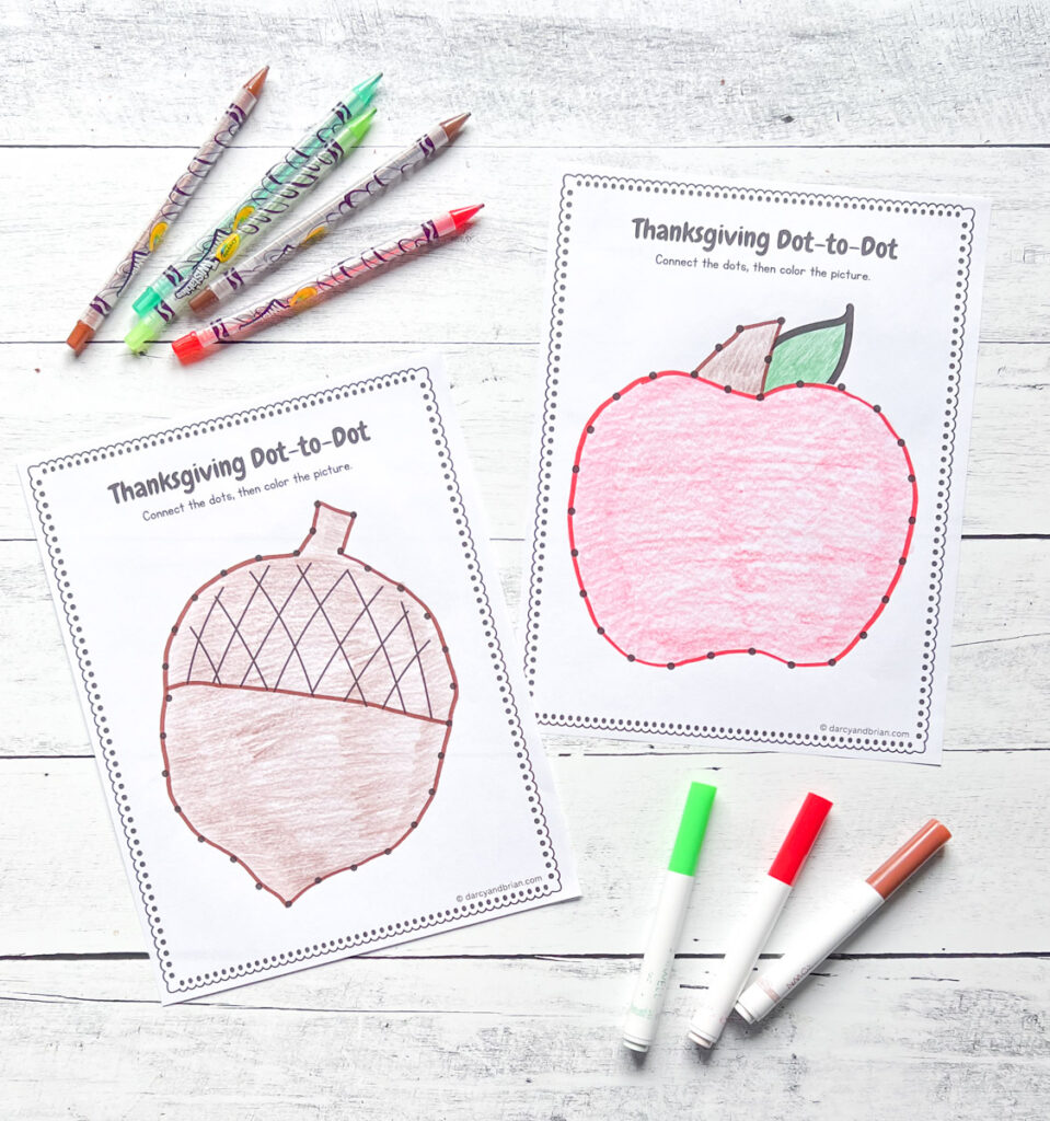 Two completed dot to dot worksheets. One with an acorn and one with an apple. They are colored in with crayons and markers.