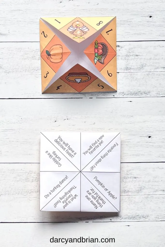  The finished assembled paper fortune teller from its outer and inner image placed in a black and white wood background.