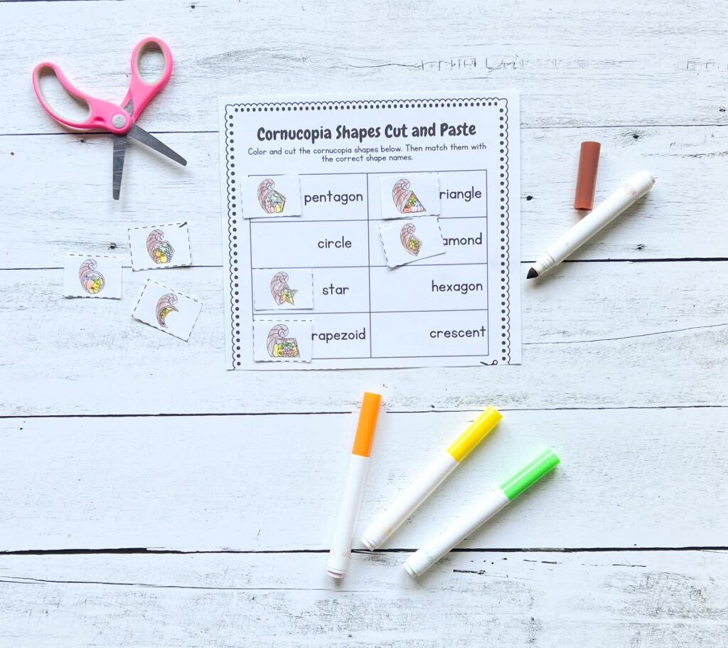 Worksheet printed out and cut apart to match cornucopia shapes to the matching word. Scissors and markers lay next to it.