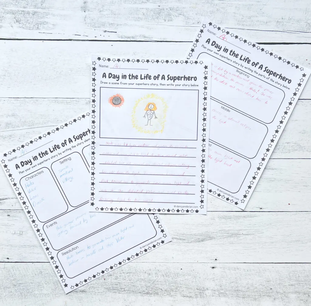 There are three pages of worksheets that kids can express themselves through drawing and writing about being a hero laying on a black and white wood background.