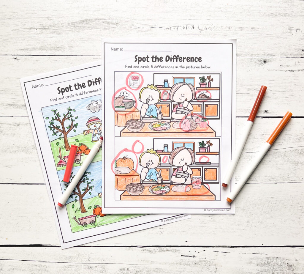 Worksheets with colors and spotted differences, with some markers on each side and all placed in a black and white wood background.