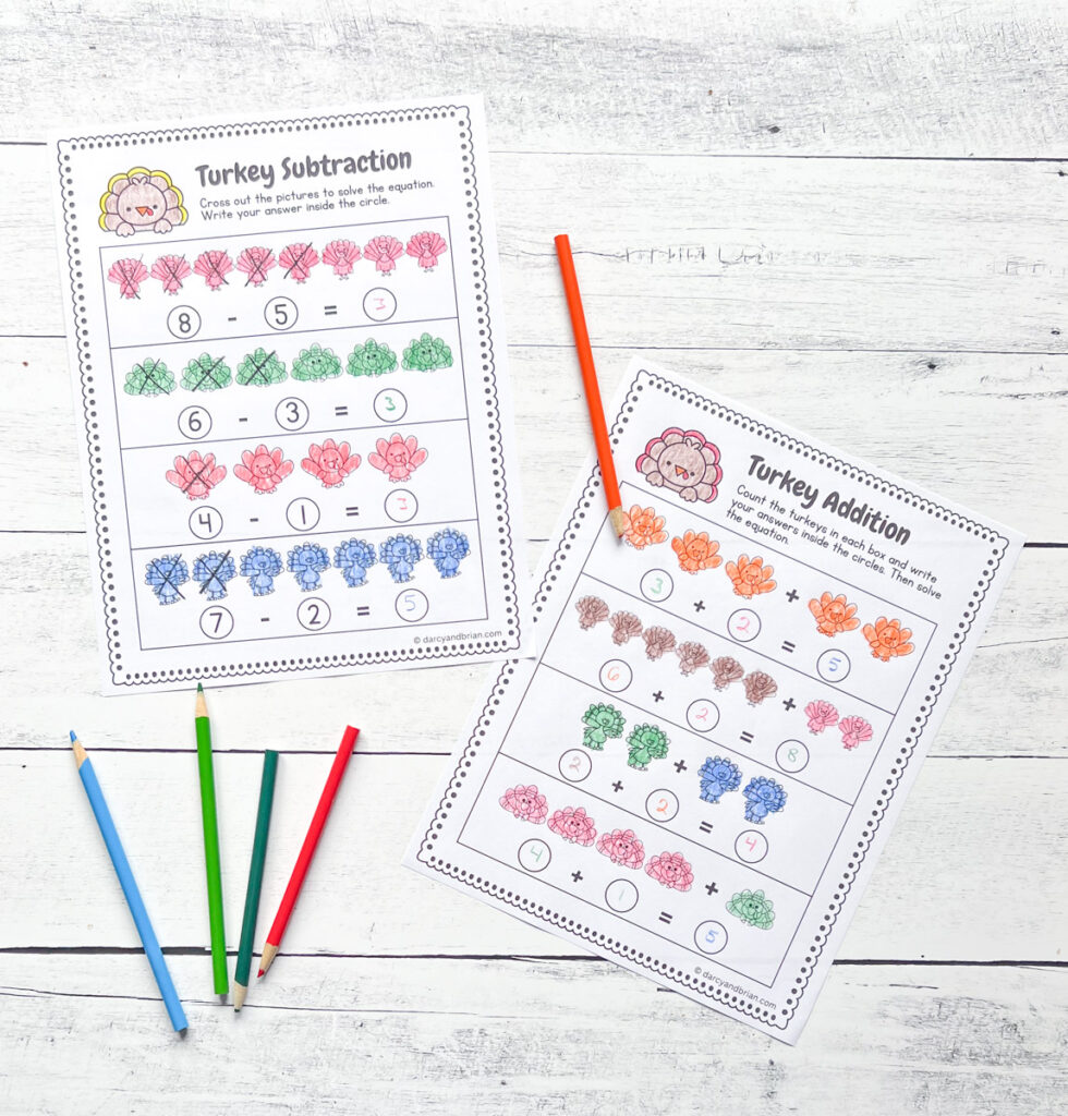 Contains two pages of printables, Subtraction and Addition, perfect for Turkey-themed activities with some color pencils all placed in a wood background.