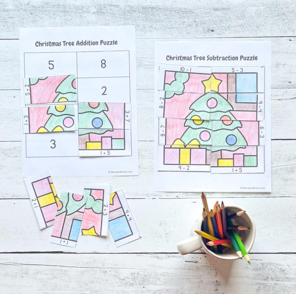 There are colorful sample of puzzle works using the Addition and Subtraction Christmas Tree Puzzle placed in a black and white background. with some color pencils.