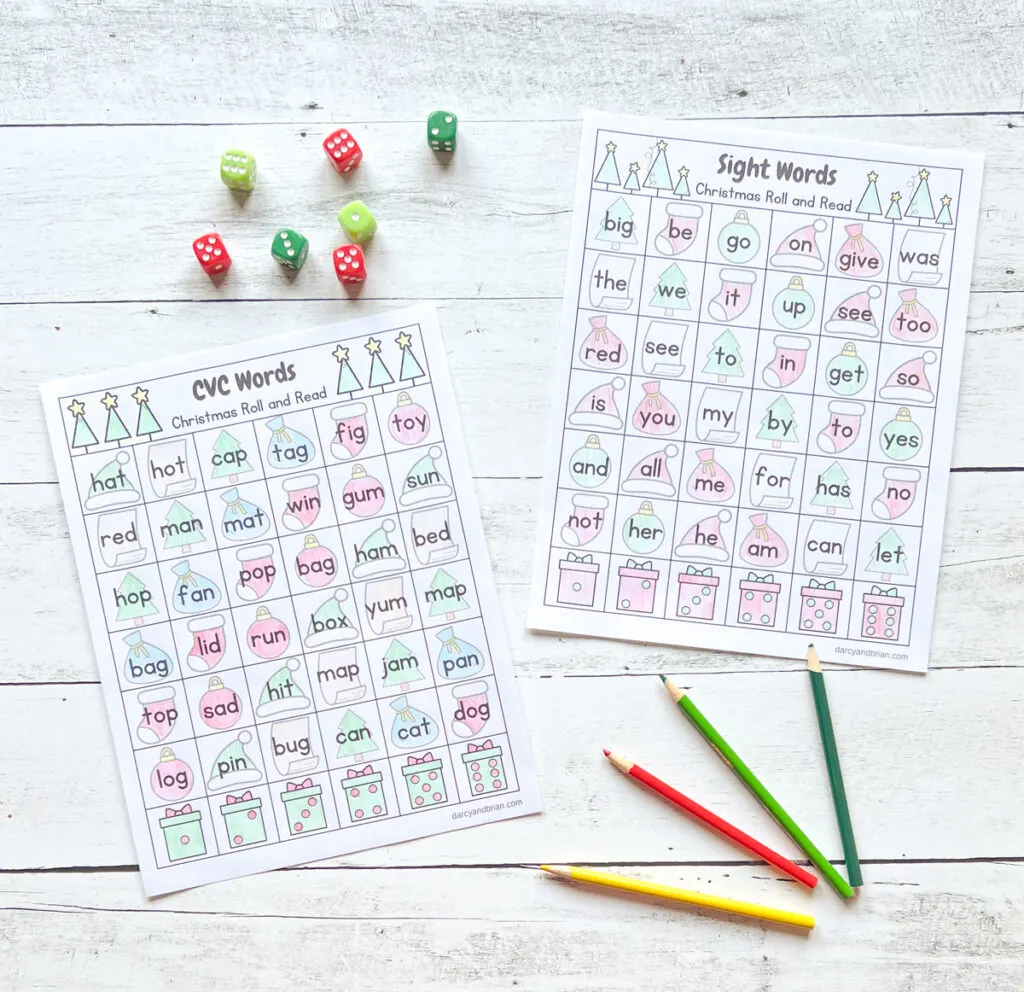 There are two pages of CVC worksheets with some dice and color pencils placed in a black and white wood background. The worksheets are colored in with red and green. The dice are red, light green, and dark green.